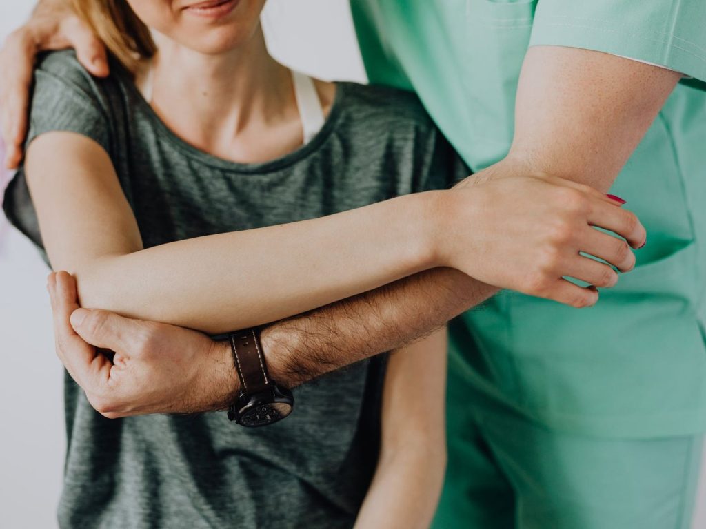 A chiropractor assessing a patient’s shoulder