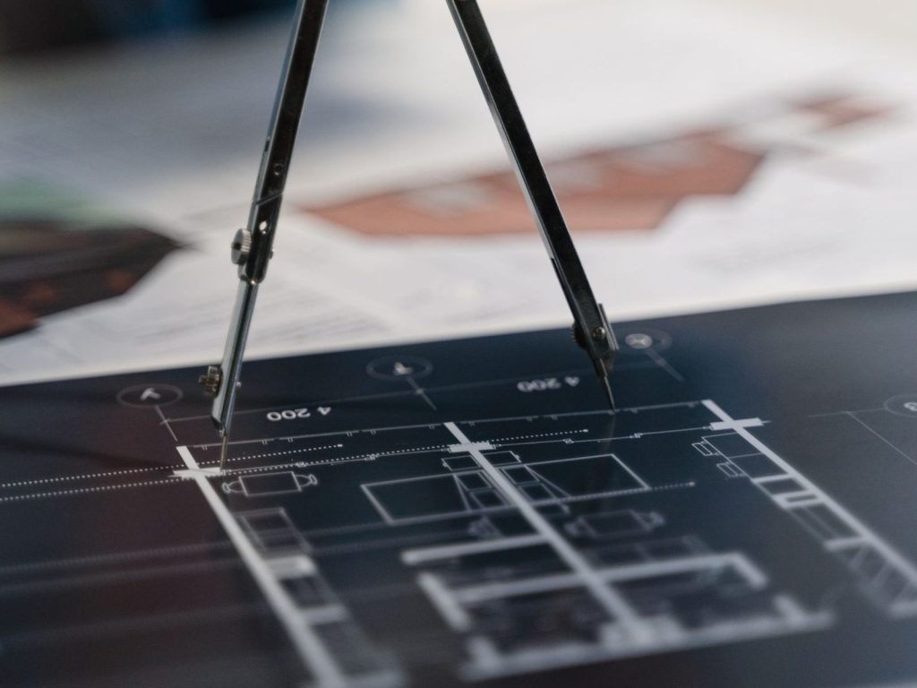 Drafting compass on technical blueprints