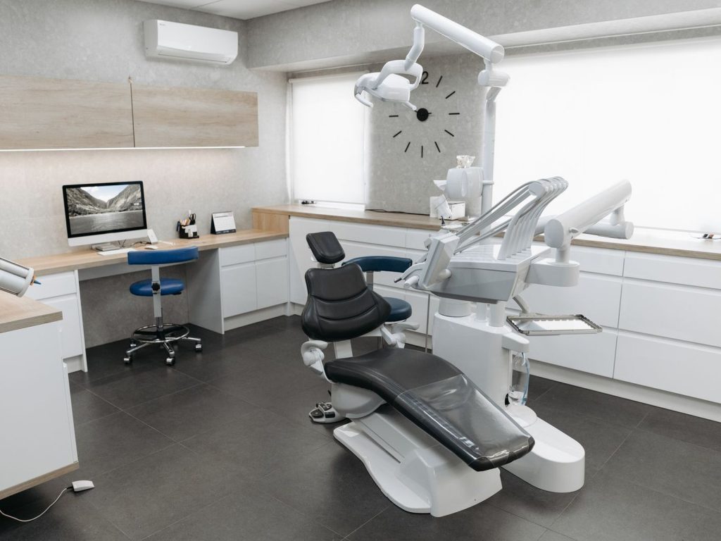 A quiet dental treatment room with a dental chair and equipment