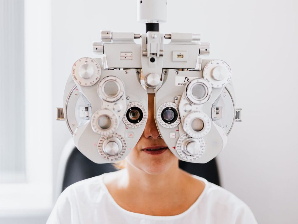 A patient having an eye exam with a phoropter