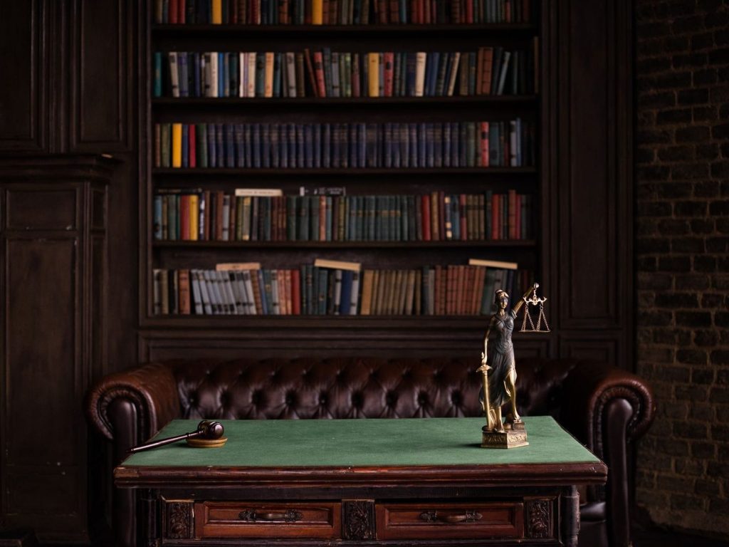 Law library with leather chairs, a desk and a Lady Justice figurine