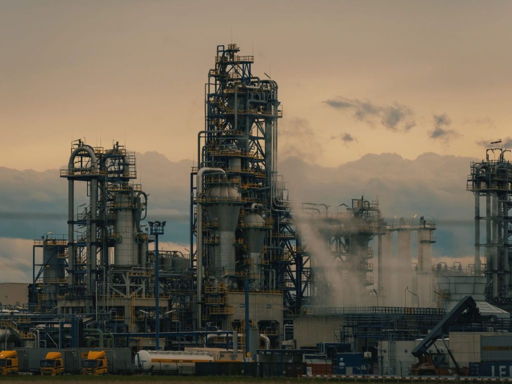 Refinery towers against a cloudy dusk sky