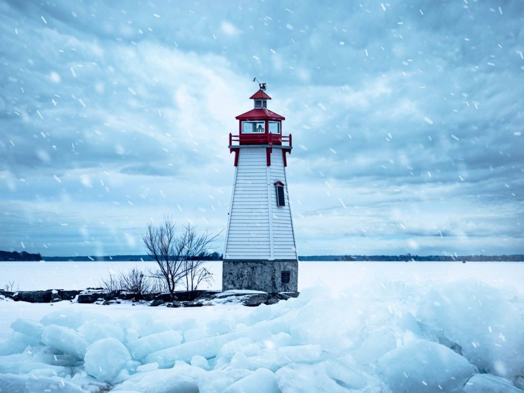 A lighthouse on a frozen lakeshore in winter