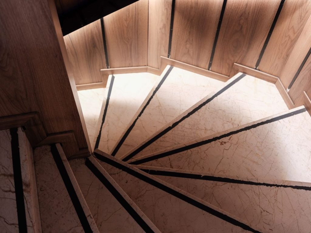Spiral staircase with marble steps and wood panelling